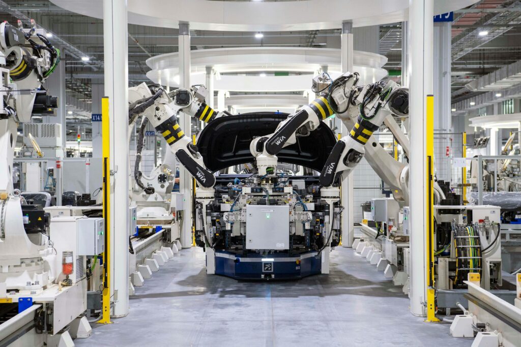 Imagem atual: High-tech robots assembling a car in a modern factory setting, showcasing automation.